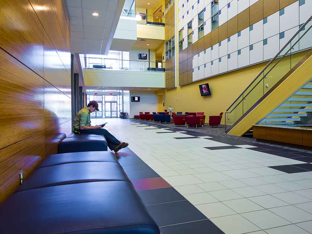 Student studying at San Jacinto College is lobby of building