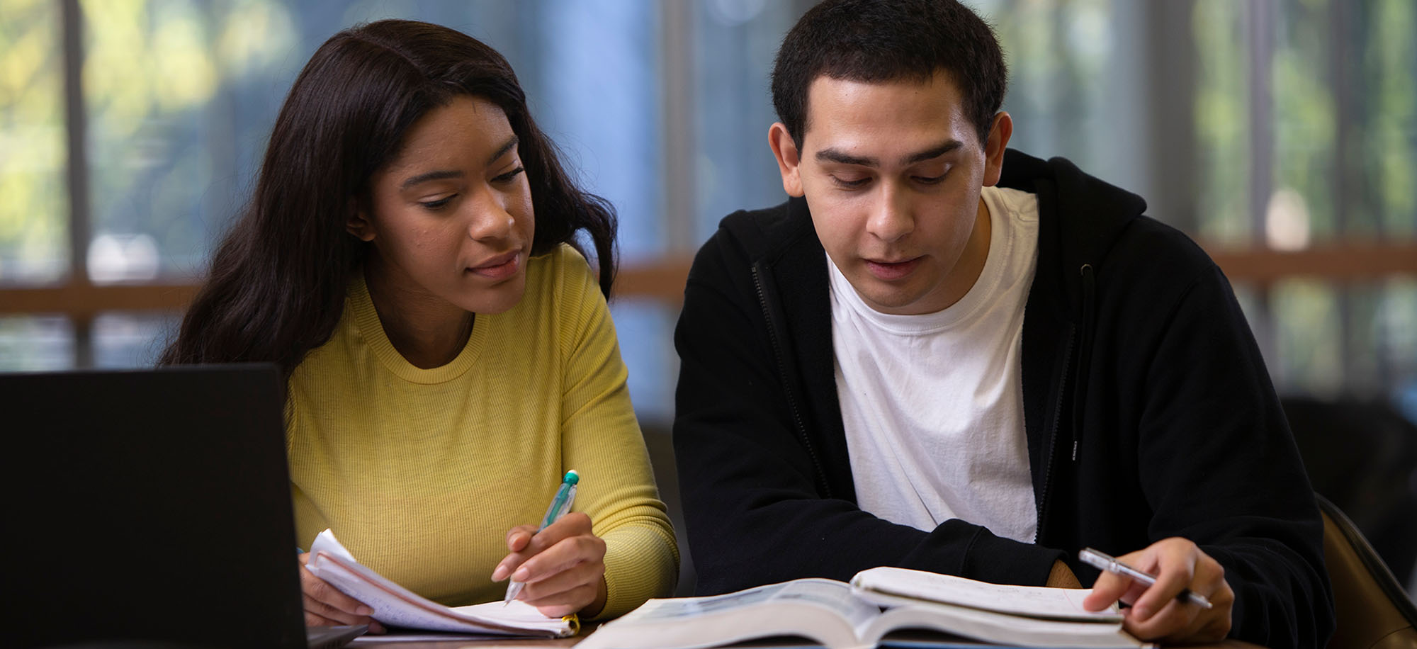 students looking at textbook together